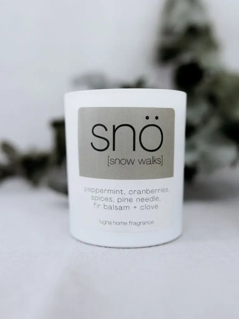 white candle jar with label saying sno